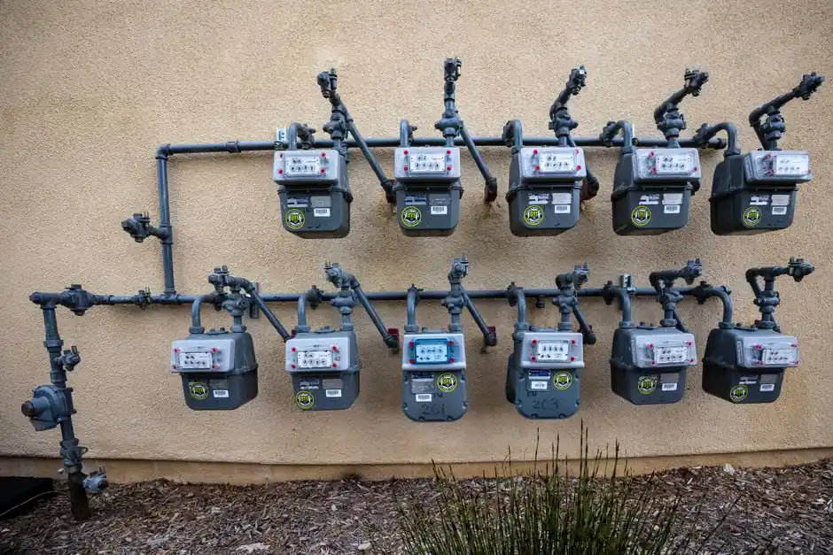 A neat installation of gas meters mounted on an exterior wall in an urban setting.