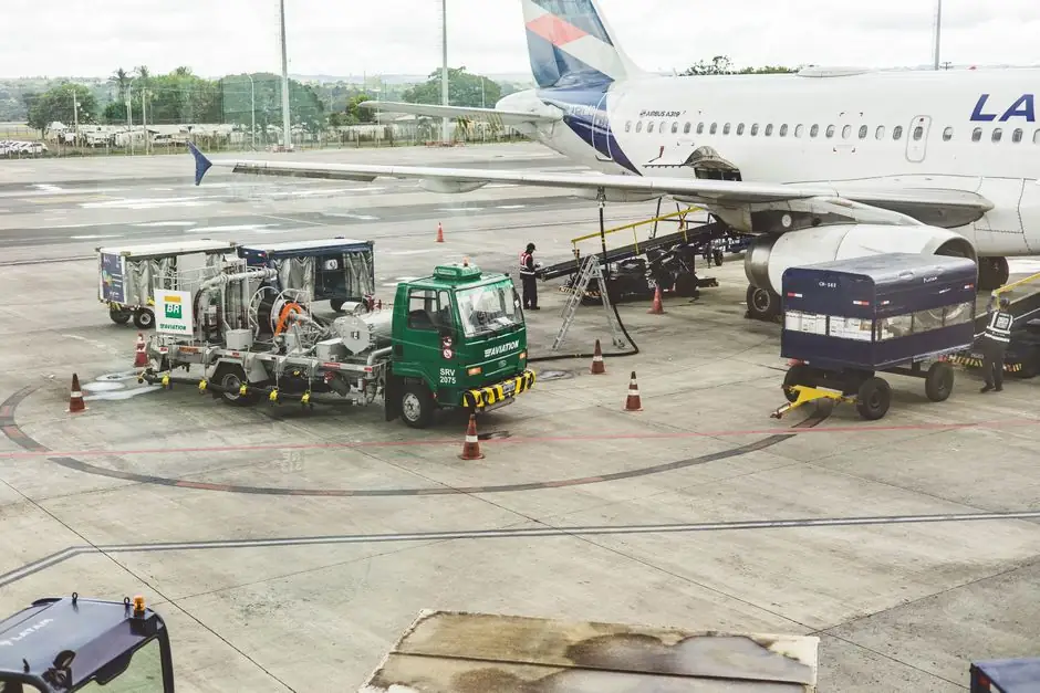 Ground support services in action at an airport terminal with visible aircraft and service vehicles.